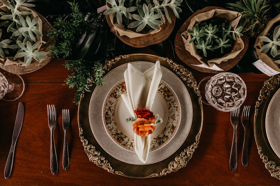 A beautifully arranged dining table with ornate plates, cutlery, and succulents for a sophisticated vibe