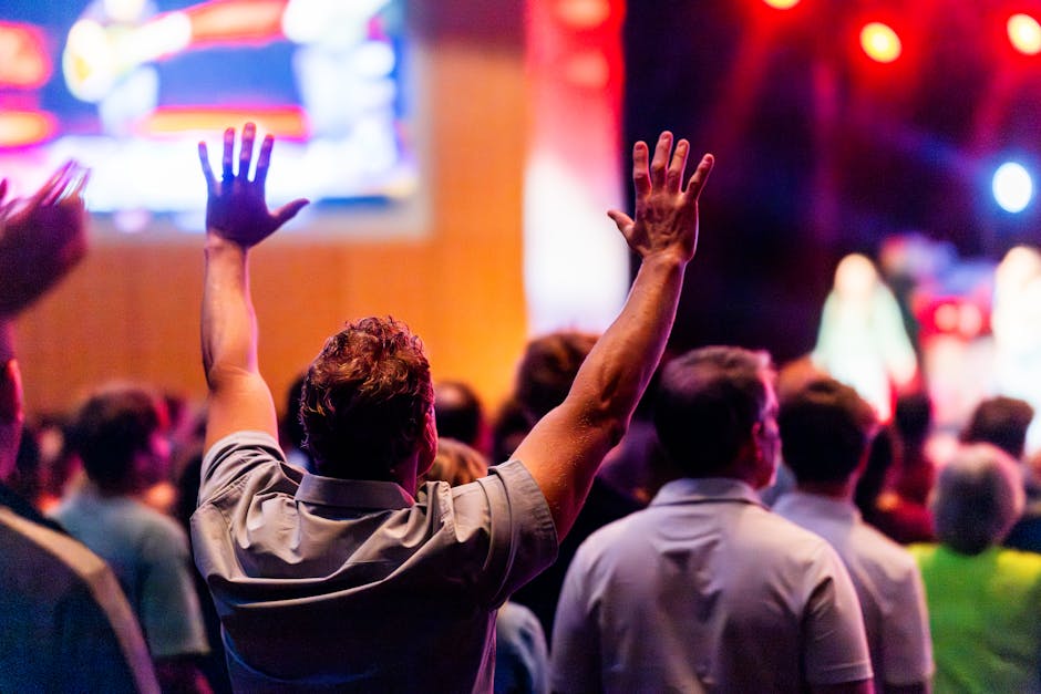 Energetic audience at a live concert with hands raised, embracing the music.